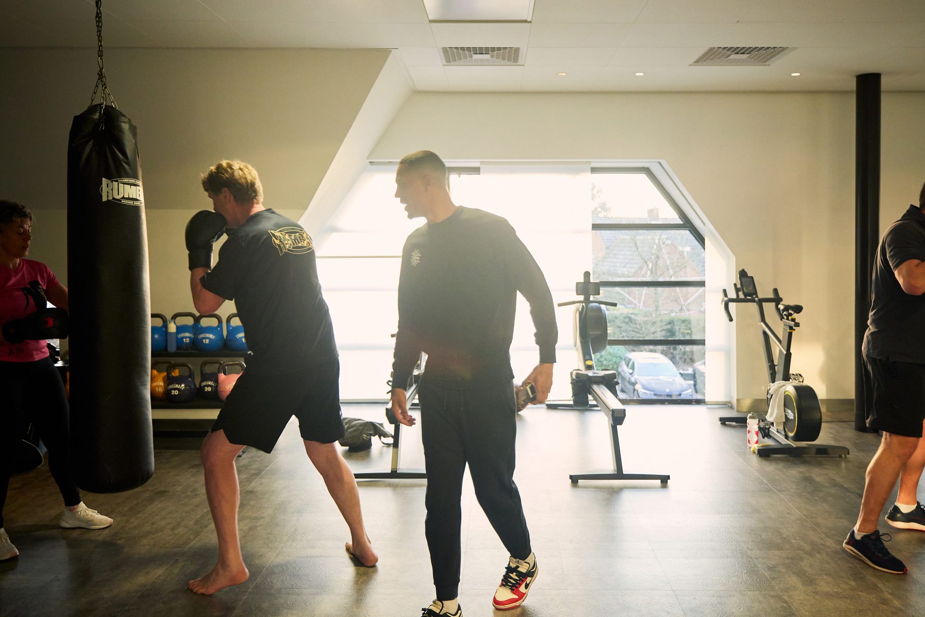 Trainer geeft uitleg bij de bokszakken tijdens HIIT Boxing
