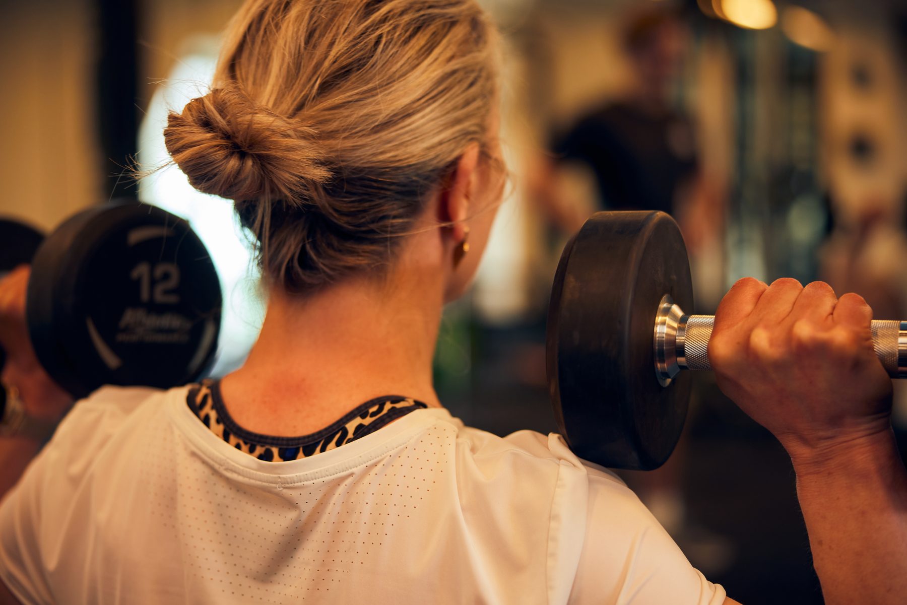 Sporter traint met dumbbells in de Open Gym