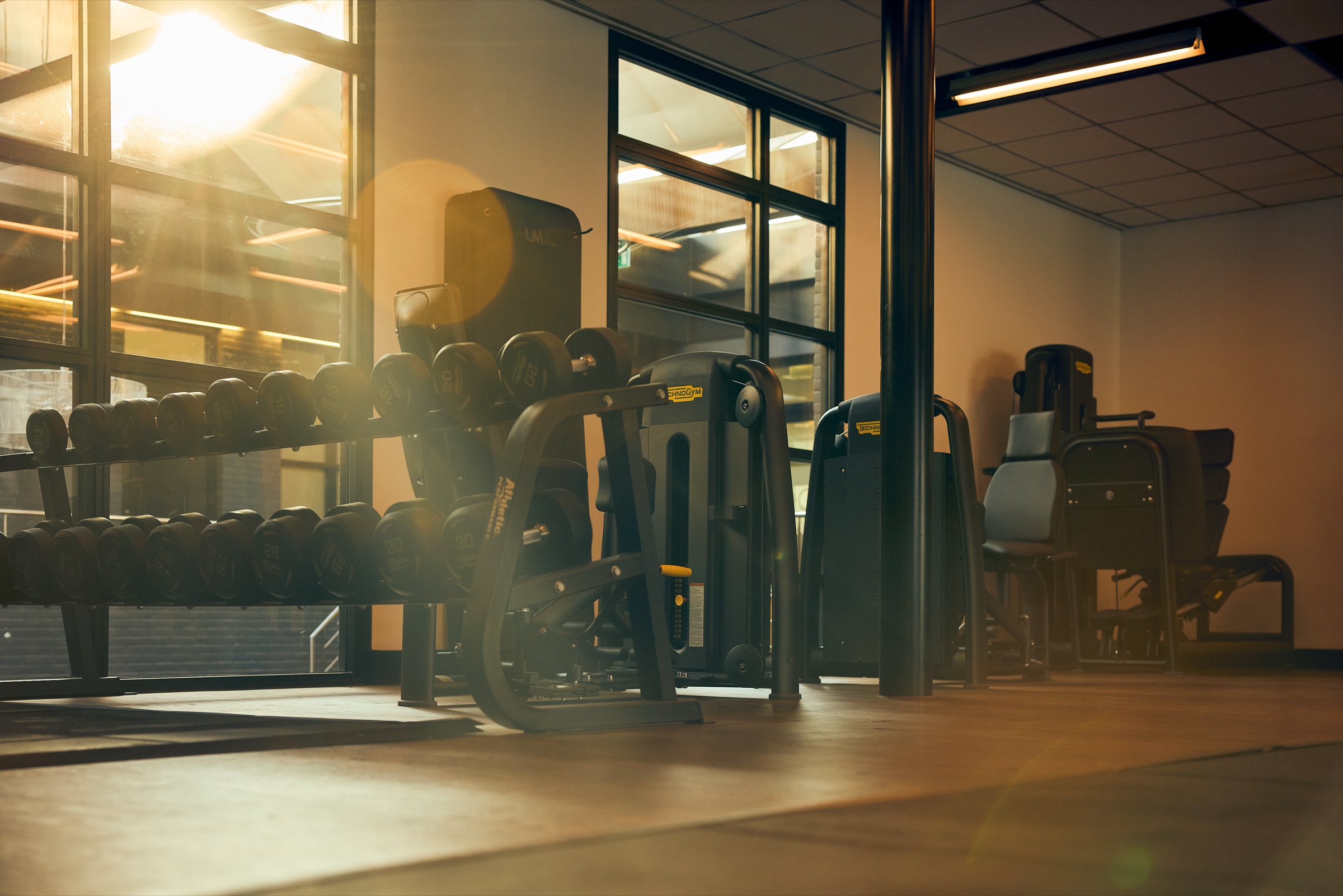 Dumbbells en Technogym-toestellen in de trainingsruimte