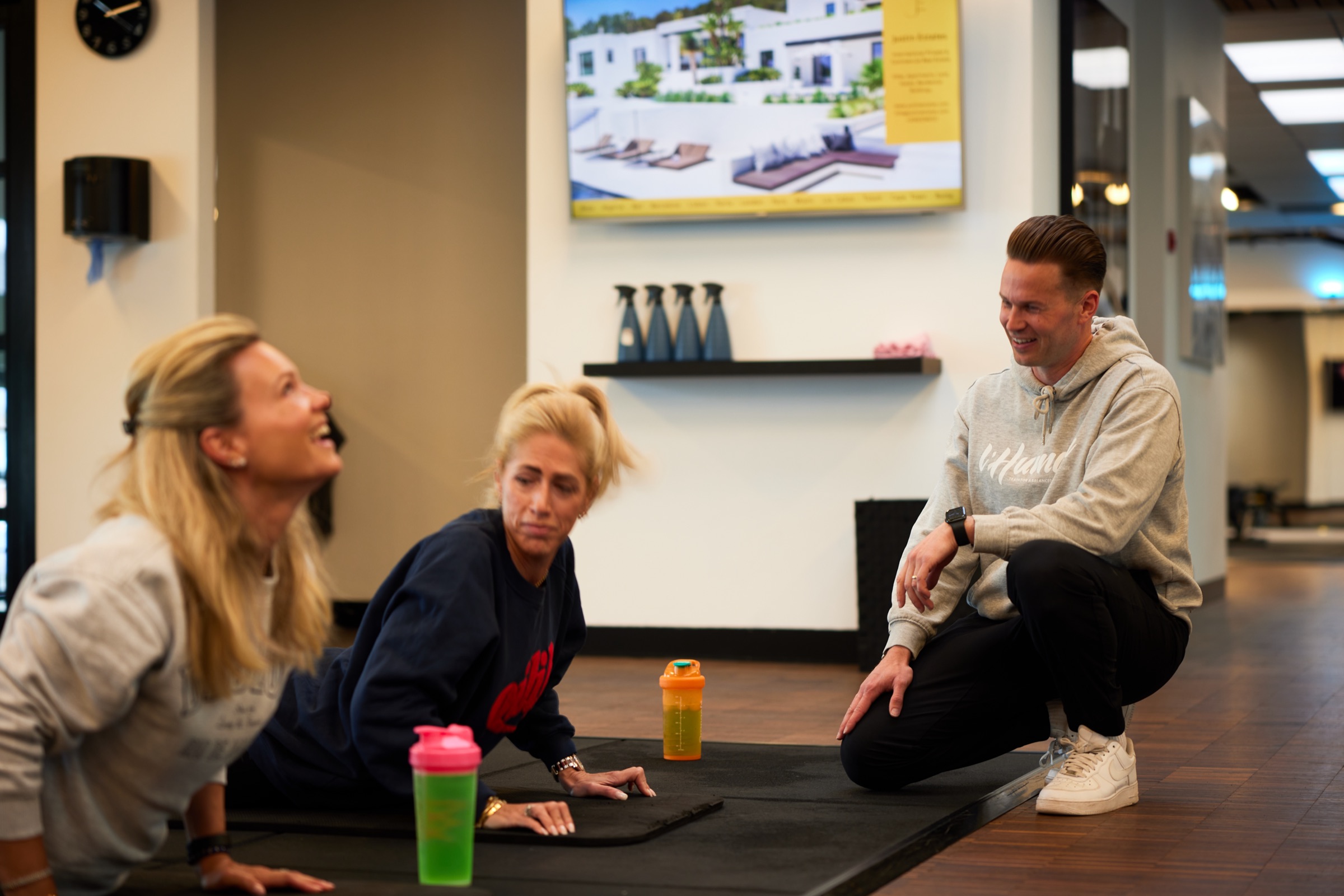 Trainer laughing with two members during a workout