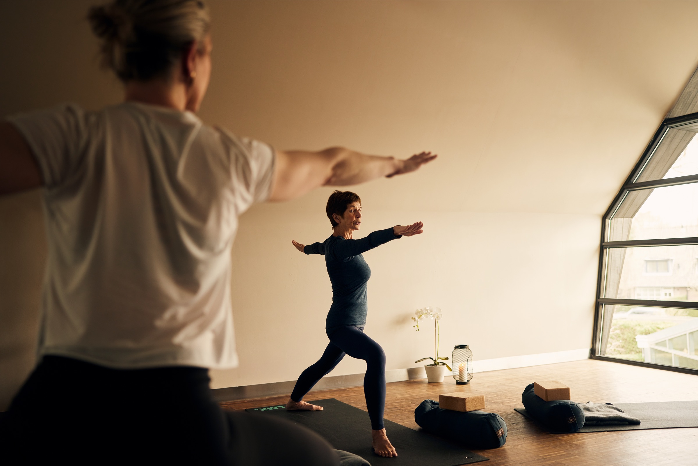 Yogadocent in de strijdershouding tijdens een les