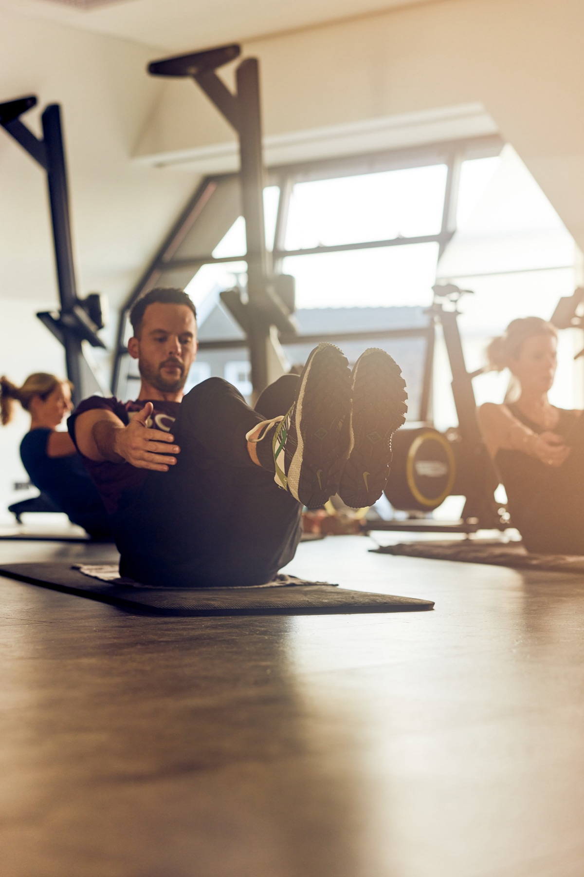 Members doing ab exercises on the mat during a HIIT class