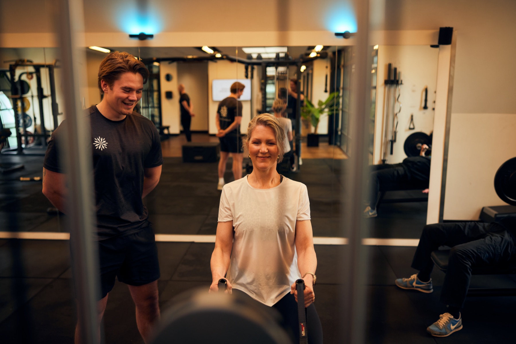 Trainer and member laughing together in the training area