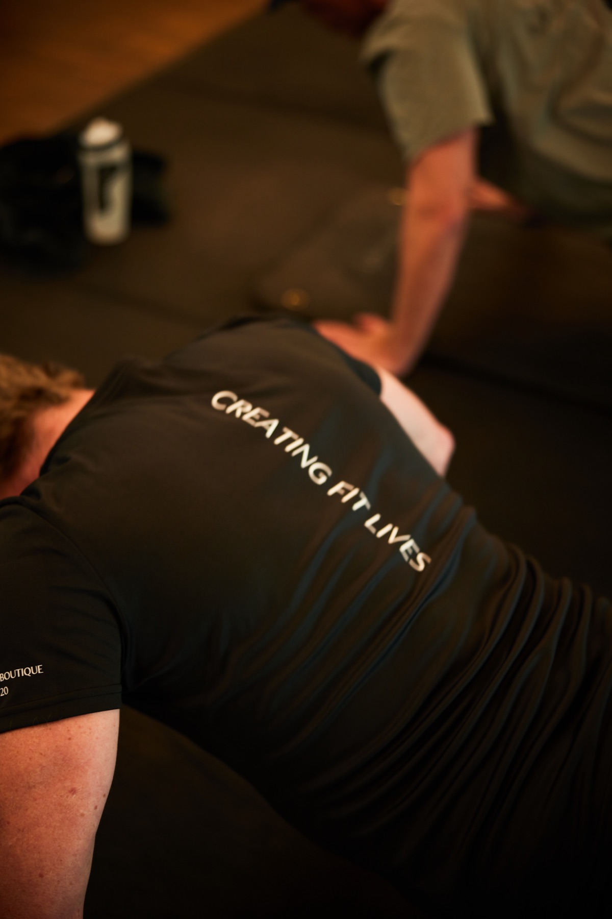 Trainer with &lsquo;Creating Fit Lives&rsquo; on the back of the shirt