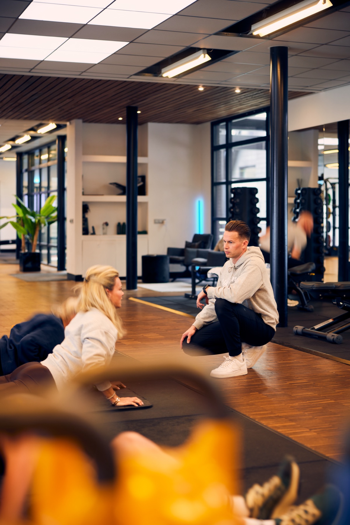 Personal trainer guiding a client on the mat